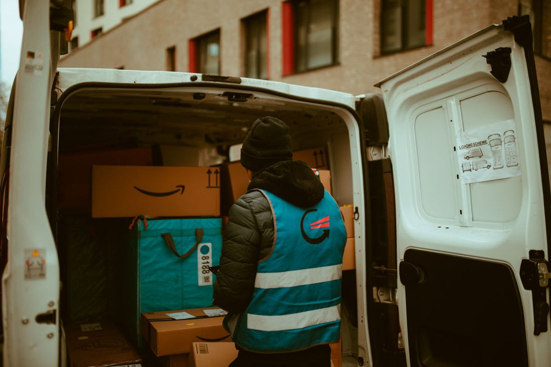 Delivery driver loading a van, representing free tire delivery when buying online in Quebec
