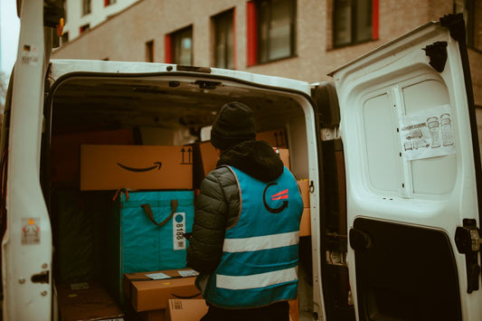 Delivery driver loading a van, representing free tire delivery when buying online in Quebec
