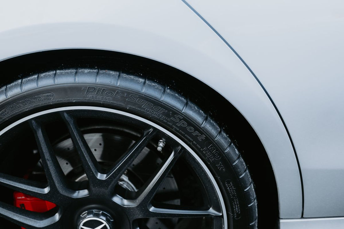 Close-up of a car tire tread, comparing Cooper and Nexen tire brands