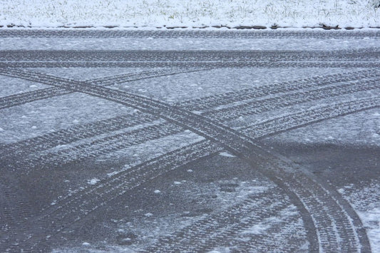 Snow-covered road with tire tracks illustrating Quebec's mandatory winter tire law