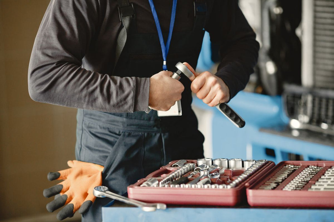 Mechanic holding a wrench in a garage, representing tire installation service and cost